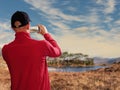 Male tourist taking picture on his smart phone of Pine island, Connemara, Selective focus, Concept travel, capture and share Royalty Free Stock Photo