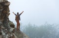 Male tourist on top of mountain in fog in autumn Royalty Free Stock Photo