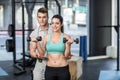 Male trainer assisting woman lifting dumbbells Royalty Free Stock Photo