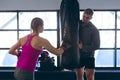 Male trainer giving boxing training to female athletic in fitness center