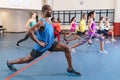 Male trainer training people to perform yoga in fitness center