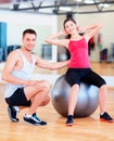 Male trainer with woman doing crunches on the ball Royalty Free Stock Photo