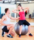 Male trainer with woman doing crunches on the ball Royalty Free Stock Photo