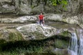 A male traveler admires waterfalls on the Agura River in Sochi