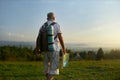 Male traveler holding map, while backpacking across rural area in mountains.