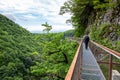 Male traveler in Okatse Canyon in Georgia, walking on hanging metal pedestrian pathway.