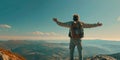 A male traveler with raised hands standing stands on the top of a mountain with white fog below. Royalty Free Stock Photo