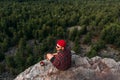 A male traveler is sitting on a rock with a bird`s-eye view of the forest. The concept of recreation and tourism. A man traveler Royalty Free Stock Photo