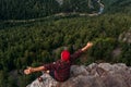 A male traveler is sitting on a rock with a bird`s-eye view of the forest. Travel, adventure lifestyle, vacation. A man traveler Royalty Free Stock Photo