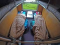 Male traveler sleeps while his girlfriend looks through the window of a train.