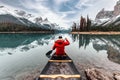 Male traveler in winter coat canoeing in Spirit Island on Maligne Lake at Jasper national park Royalty Free Stock Photo