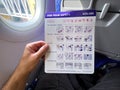 Male traveler on WizzAir airplane flight reading safety brochure before taking off