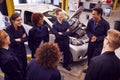 Male Tutor With Students Teaching Auto Mechanic Apprenticeship At College