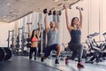 Male and two slim females doing squats.