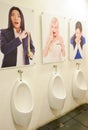 Male Urinals with poster of ladies looking