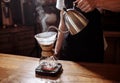 Male is using a chemex to make coffee