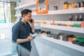 male vape store keeper calling on phone while checking the liquid stock