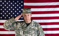 Male veteran solider saluting with USA flag in background