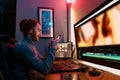 Male Video Editor sitting at his Computer using phone Royalty Free Stock Photo