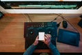 Male Video Editor sitting at his Computer using phone blank screen Royalty Free Stock Photo