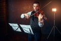 Male violinist with violin against music stand