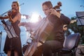 Male violoncellist playing in orchestra at outdoor concert