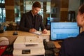 Male visitor filling registration form at reception desk Royalty Free Stock Photo