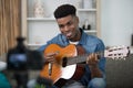 Male vlogger recording music related broadcast with guitar Royalty Free Stock Photo