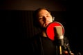 Male vocalist singing into microphone in recording studio. Creating new hit song. Royalty Free Stock Photo