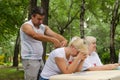 Male volunteer doing relax massage to his colleague female volunteer with in the park