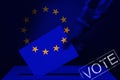 Male voter drops a ballot in a transparent ballot box against the background of the European Union national flag, concept of state Royalty Free Stock Photo