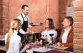 Male waiter bringing order to visitors Royalty Free Stock Photo