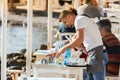 A male waiter clearing a table outdoors at a greek tavern in the waterfront of Mykonos, Greece