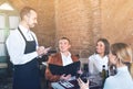 Male waiter taking order from visitors Royalty Free Stock Photo