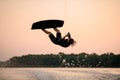 male wakeboarder skilfully jumping and flips on wakeboard over splashing wave Royalty Free Stock Photo