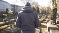 Male walking on cemetery, talking to soul of dead, feeling sorrow and pain