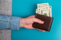 Men`s hands hold a leather wallet with dollar bills. Royalty Free Stock Photo