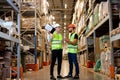 male warehouse managers in work wear organizing distribution in warehouse storage area. Royalty Free Stock Photo