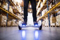 Male warehouse worker on hoverboard.