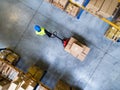 Male warehouse worker pulling a pallet truck.