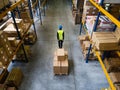 Male warehouse worker pulling a pallet truck.