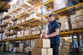 Male warehouse worker sealing cardboard boxes. Royalty Free Stock Photo