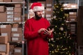 Male warehouse worker working at christmas time using digital tablet to inventory warehouse. Christmas delivery Royalty Free Stock Photo