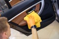 Male washer in gloves wipes car door with microfiber closeup Royalty Free Stock Photo