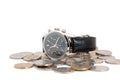 Male watch lying on coins, isolated