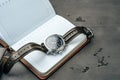 Male watch and notepad on dark grey table