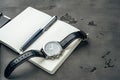 Male watch and notepad on dark grey table