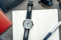 Male watch and notepad on dark grey table