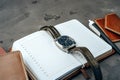 Male watch and notepad on dark grey table