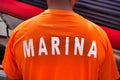 Male wearing an orange t-shirt with the word "navy" printed